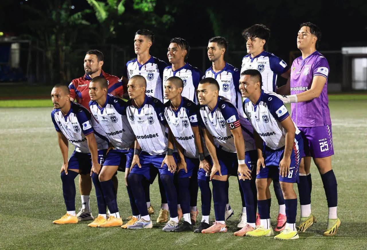 Equipo posando para la foto oficial en una cancha iluminada de noche